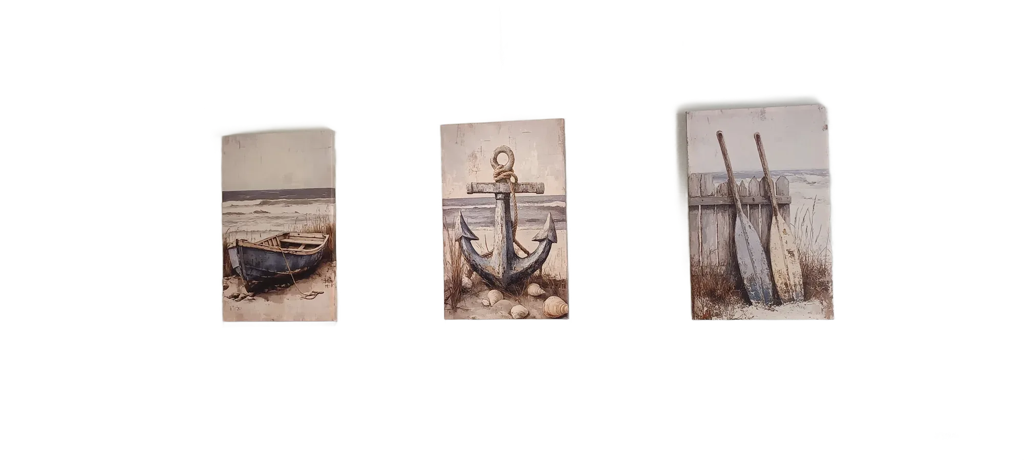 Trois toiles décoratives au thème marin représentant une barque, une ancre et deux avirons, accrochées côte à côte sur un mur vert pâle.